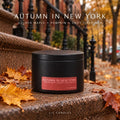 Autumn in New York maple and pumpkin scented candle in a matte black tin on a Brooklyn brownstone stoop surrounded by autumn leaves