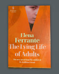 The Lying Life of Adults — Elena Ferrante book cover on slate-gray background